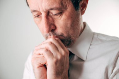 Yüzüne yakın duran düşünceli iş adamı, derin konsantrasyon ve ilgi, karar verme ve temiz arka plan üzerine zihinsel baskı konsepti. Seçici odak.