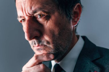 Derin düşüncelere dalmış, eli çenesinde, dramatik ışıklandırma, seçici odaklanma...