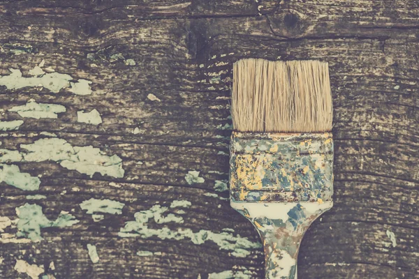 Vieux pinceau utilisé sur une planche de bois rustique — Photo