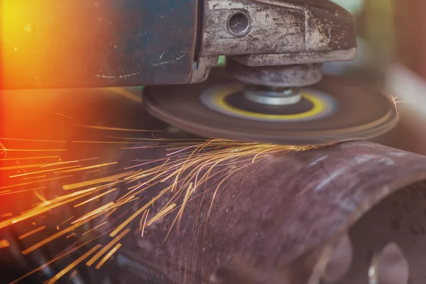 Worker grinding steel pipe with grinder — Stock Photo, Image