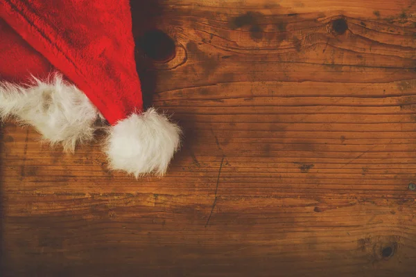 Retro afgezwakt Kerstman hoed op houten bureau — Stockfoto