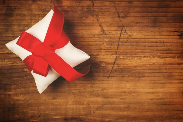 Kerstcadeau verpakt en gebonden met rood lint — Stockfoto