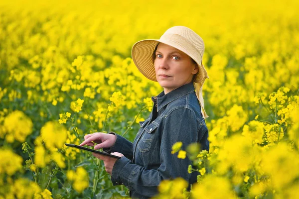 女性农民与数字平板油料油菜栽培 — 图库照片