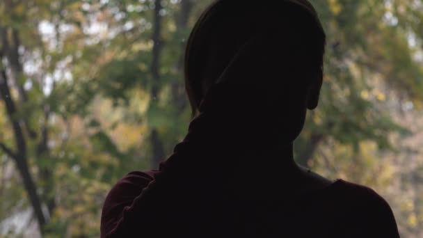 Silhouette di persona femminile solitaria dalla finestra — Video Stock