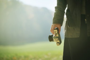 Hipster female photographer exploring nature in autumn