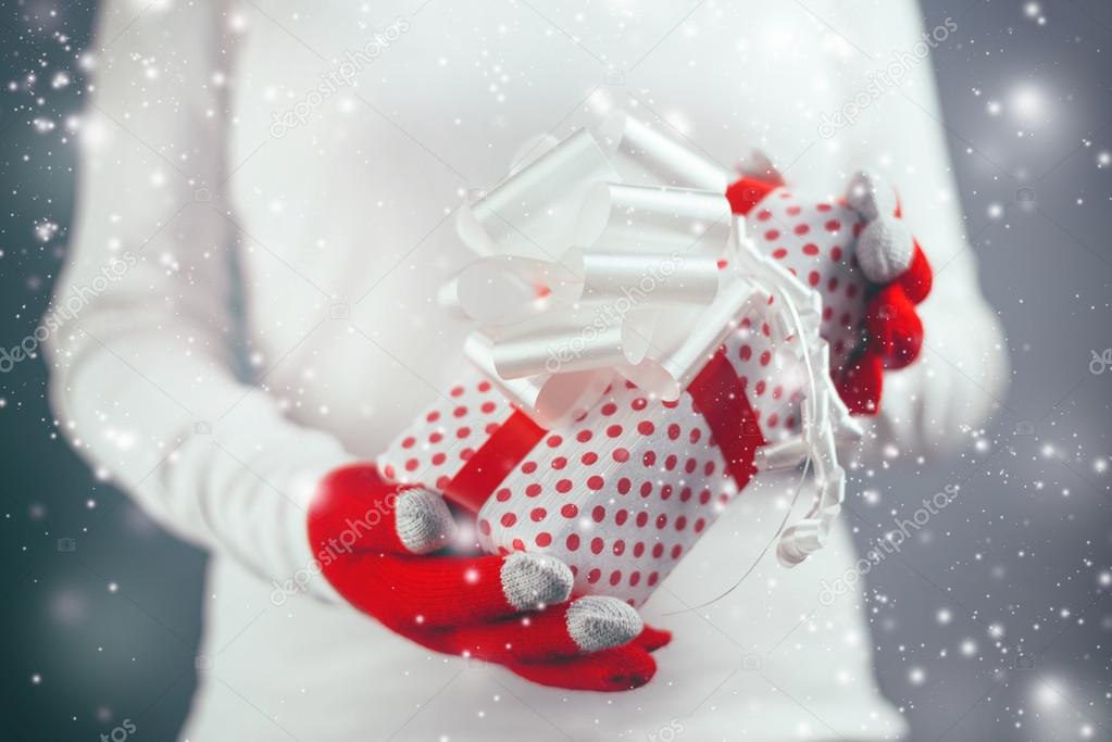 Woman offering Christmas gift in wrapped box