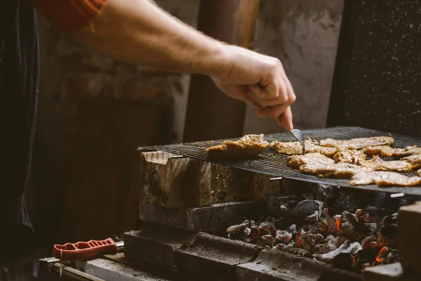 Člověk grilování vepřového masa kotlety na grilu — Stock fotografie