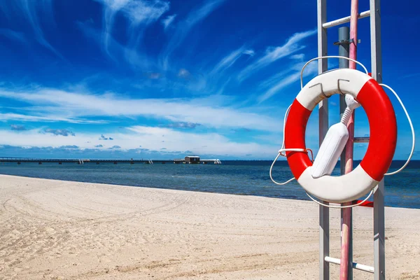 Lifebuoy on sandy beach — Stock Photo, Image