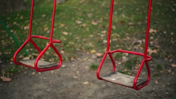 Empty swing seat swaying in park playground — Stock Video