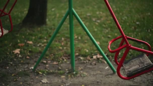 Empty swing seat swaying in park playground — Stock Video