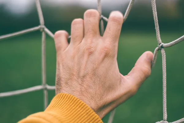 Mão masculina segurando futebol líquido — Fotografia de Stock