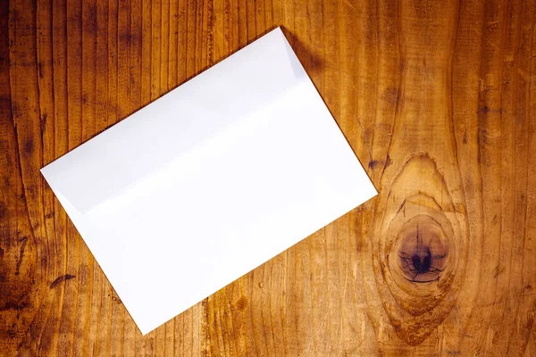 Blank white envelope on wooden desk — Stock Photo, Image