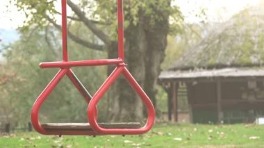 Park oyun alanında sallanan boş kırmızı salıncak koltuk
