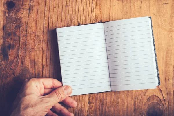 Hombre volteando páginas de cuaderno en blanco — Foto de Stock