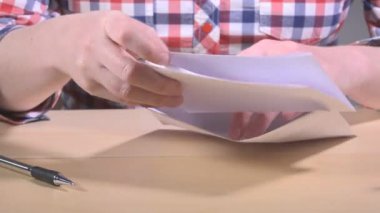 Katlanmış mektup posta zarfa koyarak kadın