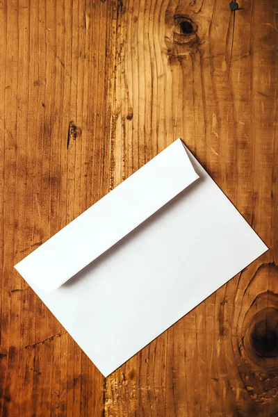 Пустой белый почтовый конверт на столе — стоковое фото