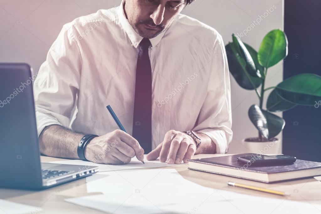 Businessman sketching business diagram at office desk