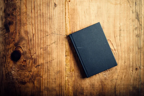 Notebook preto na mesa de escritório de madeira — Fotografia de Stock