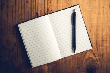 Açık defter ile boş sayfaları ve kalem