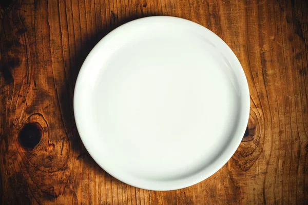 Ahşap masa üzerinde boş yemek tabağı