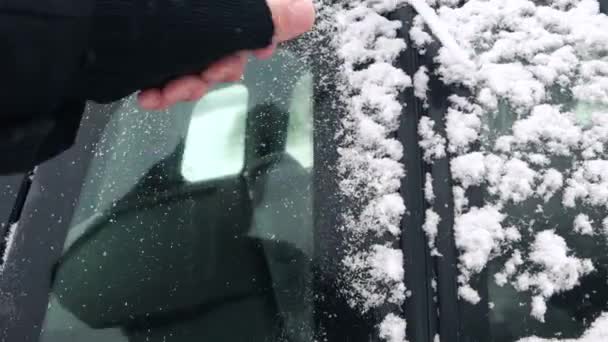 Человек выметает снег из окон машин — стоковое видео