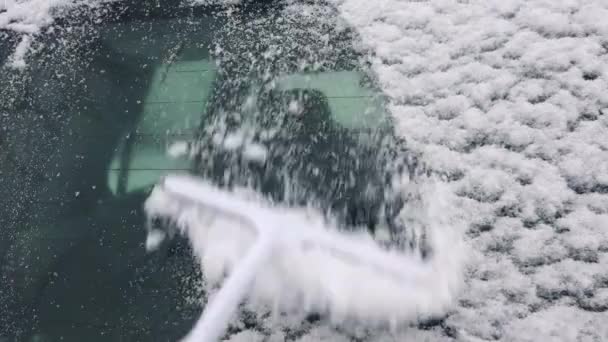 Hombre barrer la nieve de las ventanas del coche — Vídeo de stock