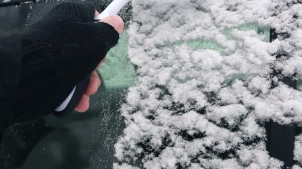 Hombre barrer la nieve de las ventanas del coche — Vídeos de Stock