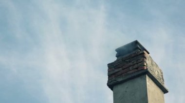 Evin çatısındaki bacadan duman geliyor.