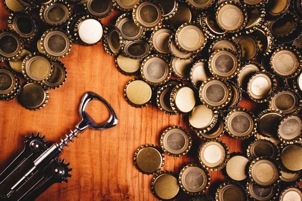 Deschizător de sticlă clasic și grămadă de capace de sticlă de bere — Fotografie, imagine de stoc
