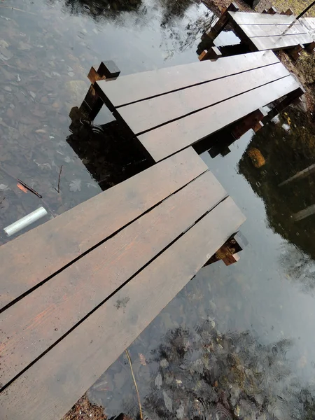 Houten voetgangersbrug over vijver, regenachtige dag — Stockfoto