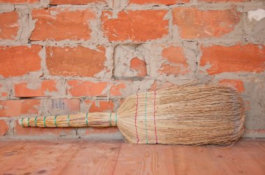 Saman süpürge ve turuncu tuğla duvar