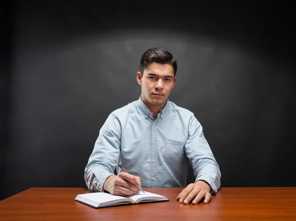 Studentin sitzt am Holztisch — Stockfoto