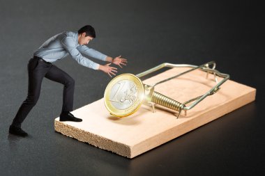 Businessman with gold coin in mousetrap clipart