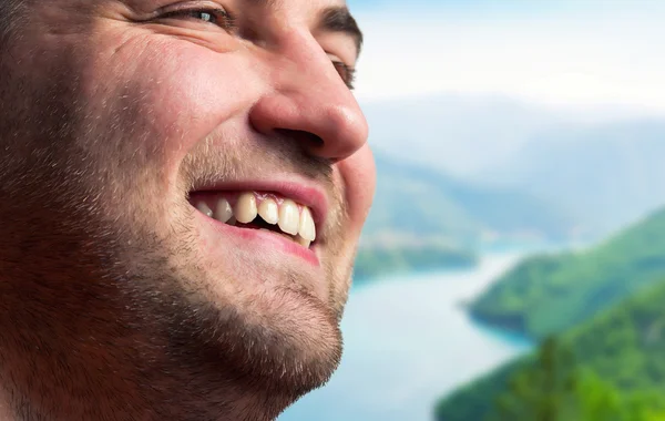 Uomo sorridente in montagna — Foto Stock