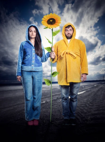 Strange couple holding sunflower — Stock Photo, Image