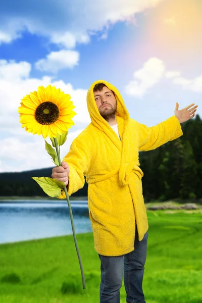 Man in the monitor holding a sunflower — Stock Photo, Image