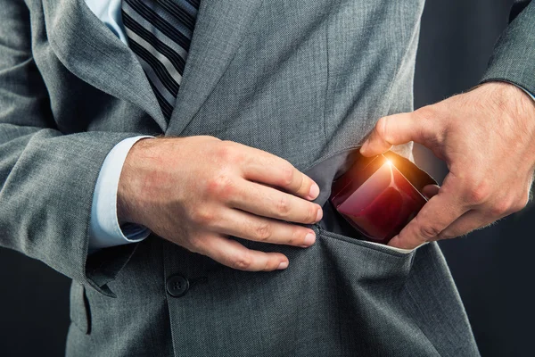 Mann steckt eine Geschenkbox in die Tasche — Stockfoto