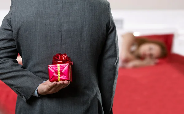 Hombre con un regalo a sus espaldas — Foto de Stock