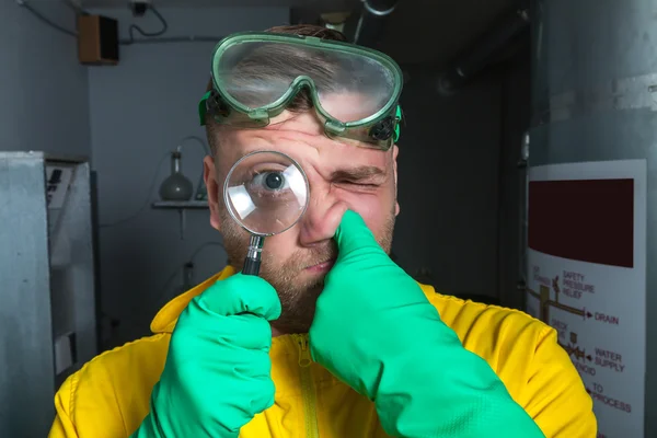 Man in the lab with magnifier — Stock Photo, Image