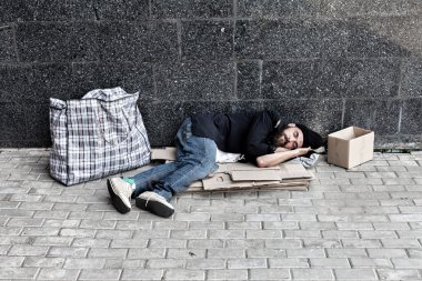 Homeless sleeping on cardboard clipart