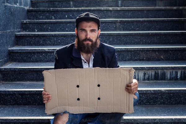 Dakloze zitten met stuk karton — Stockfoto