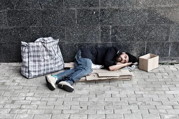 Obdachlose schlafen auf Pappe — Stockfoto