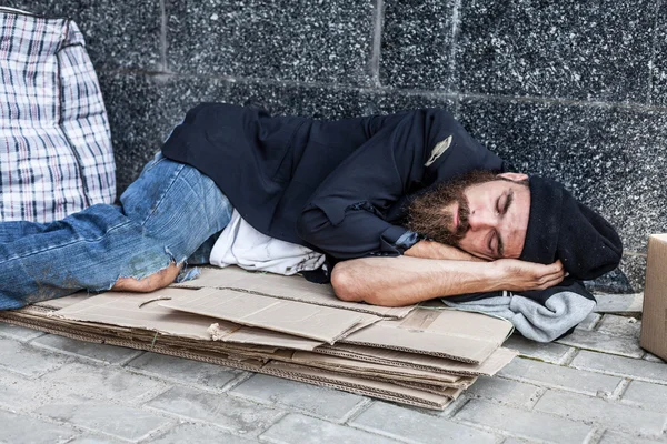 Obdachlose schlafen auf Pappe — Stockfoto