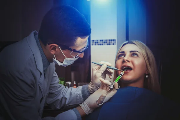 Joven dentista tratando a mujer —  Fotos de Stock