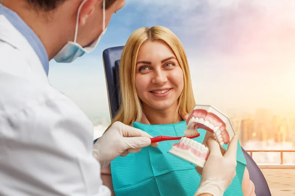 Dentist cleaning artificial jaw — Stock Photo, Image