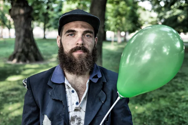 Bebaarde dwaalgast met ballon — Stockfoto