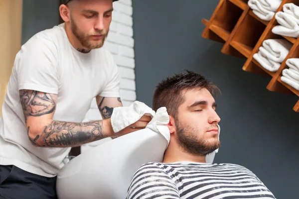 Barbier essuyant la tête de son client — Photo