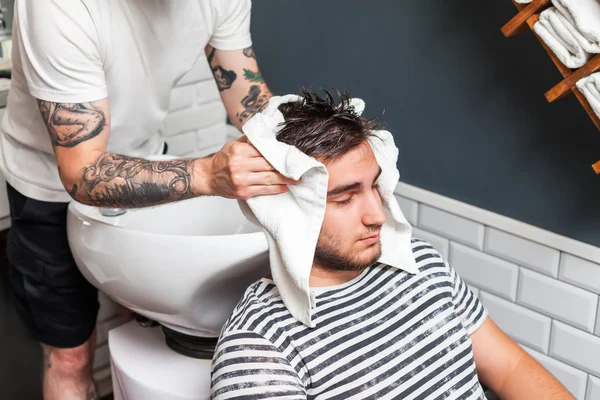 Barbier essuyant la tête de son client — Photo