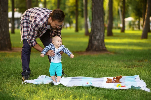 Mutlu ebeveyn ve küçük bebek çimenlerde oynuyorlar — Stok fotoğraf