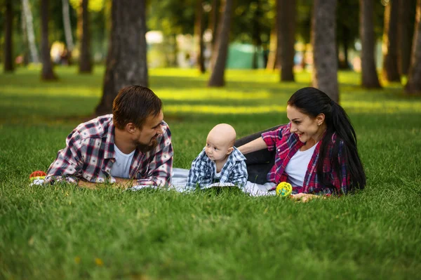 Mãe, pai e bebê pequenos lazeres no parque — Fotografia de Stock